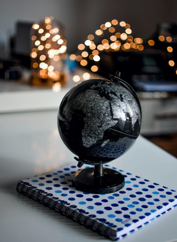 pexels photo 1236421 1236421 Elegant black globe and notebook against warm bokeh lights, perfect for educational themes.